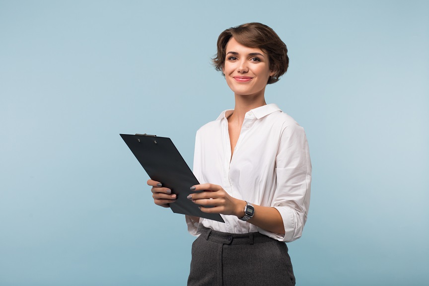 Beautiful business woman with dark short hair in white shirt holding black folder in hands joyfully looking in camera over blue background